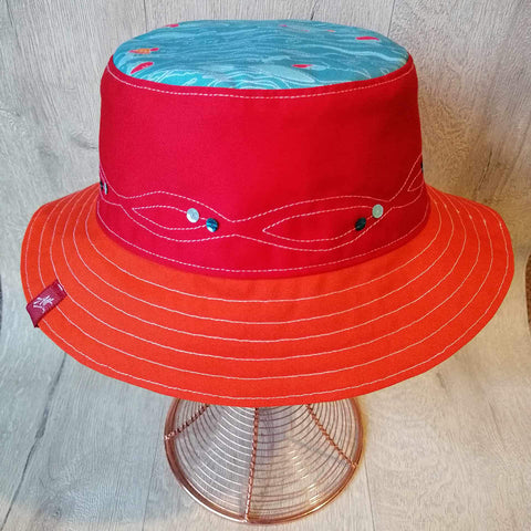 Reversible swimmer's festival bucket hat featuring outdoor swimmers