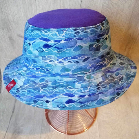 Reversible festival bucket hat in purple with Open water swimmers and waves