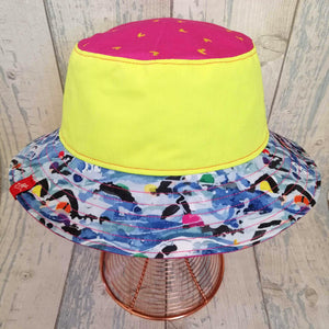 Reversible festival bucket hat in bright pink and neon yellow with swimmers