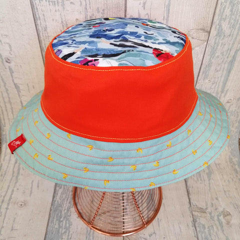 Reversible festival bucket hat in bright orange and neon yellow with swimmers