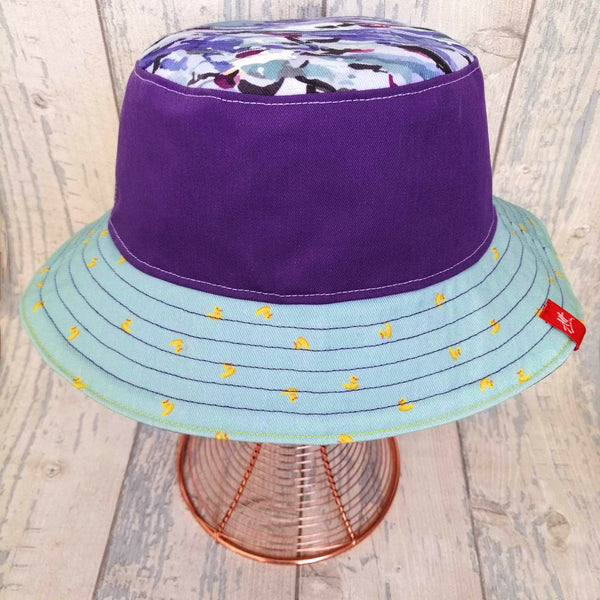 Reversible festival bucket hat in purple with yellow trim and swimmers