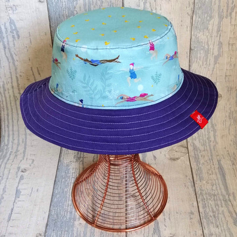 Reversible festival bucket hat in mainly purple and swimming ladies design