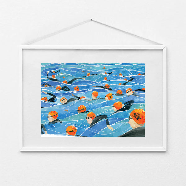 Framed A4 art print of the Great North Swim mass start, showing swimmers in orange swim caps and wetsuits in open water. Print shown in a white frame (not included).