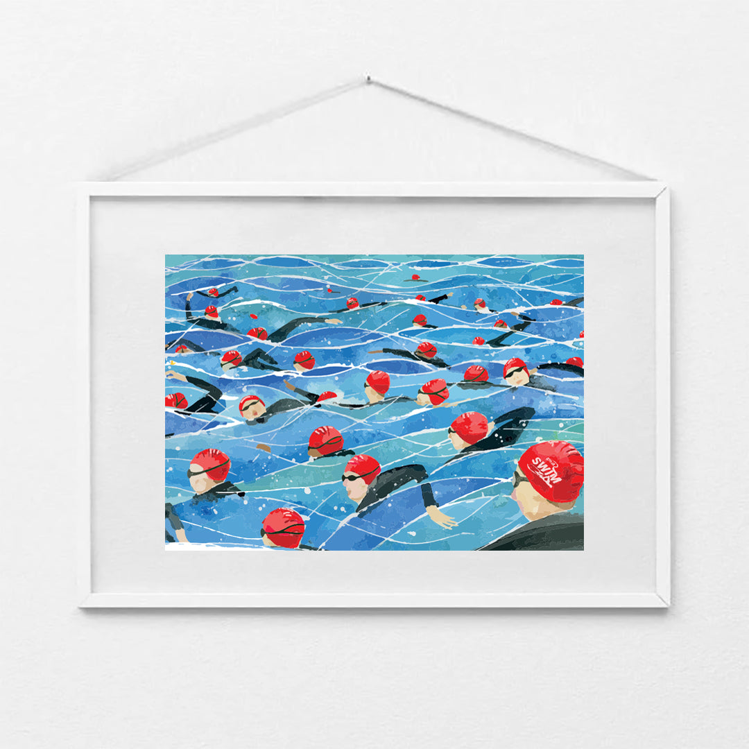 Framed A4 art print of the Great North Swim mass start, showing swimmers in red swim caps and wetsuits in open water. Print shown in a white frame (not included).