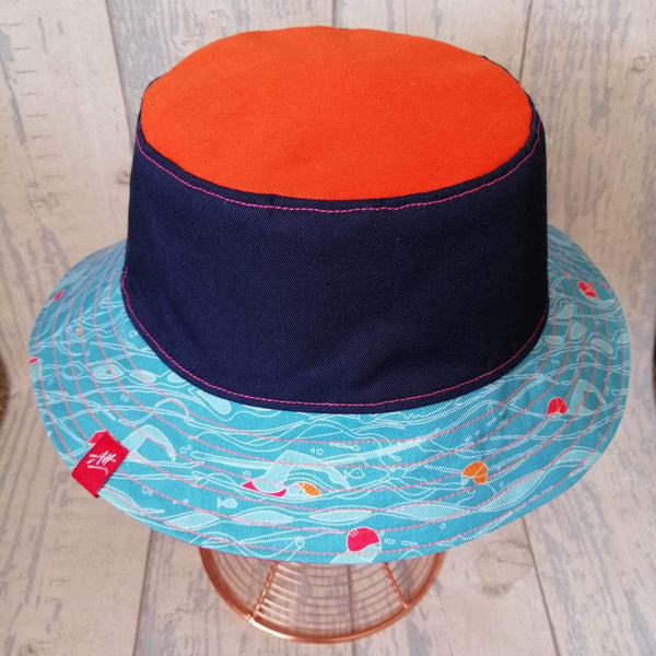 Reversible swimmer's festival bucket hat in orange, navy and turquoise