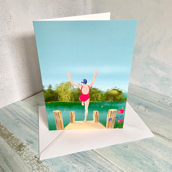 Greeting card with a person in a swimsuit standing on a jetty over water, with a matching envelope.