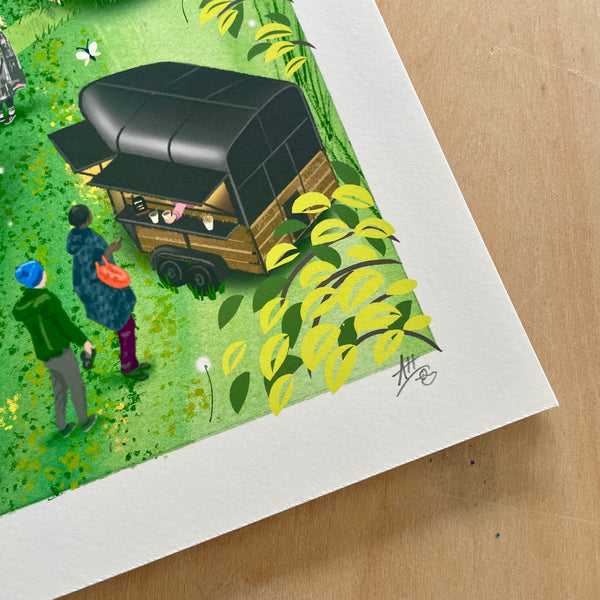 A sore of the corner of a square art print of Swillington Wilds by Andrea Hall featuring her signature, placed on a light wood surface.