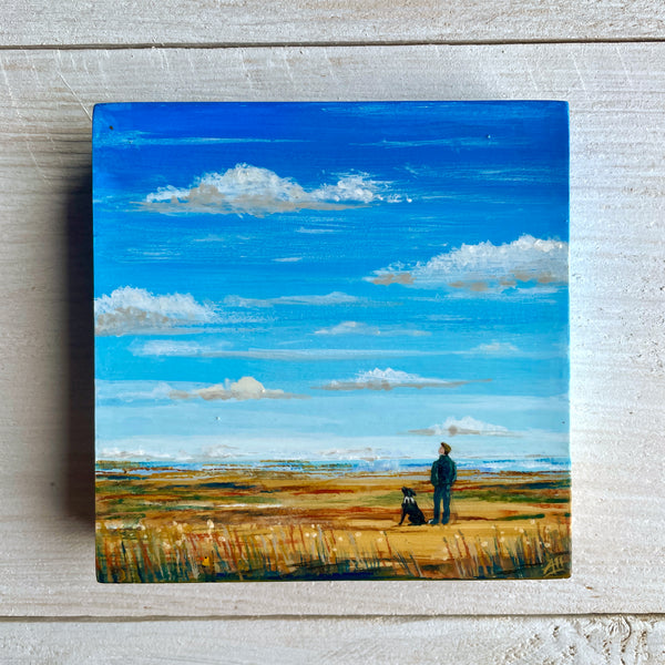 Painting of a man and dog standing on a grassy field with a big blue sky.