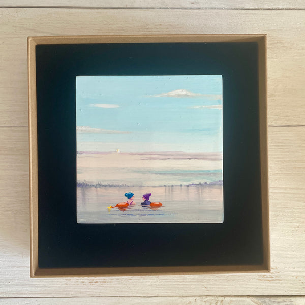 Boxed artwork of two swimmers in a misty lake.