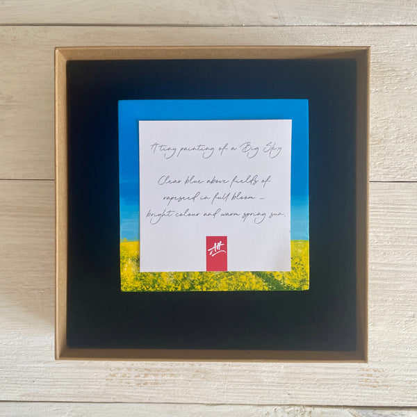 Original miniature Big Sky painting of rapeseed fields beneath a blue sky with a figure walking through. Presented in display box with descriptive label