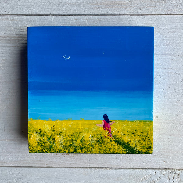 Original miniature Big Sky painting of rapeseed fields beneath a blue sky with a figure walking through, by Andrea Hall