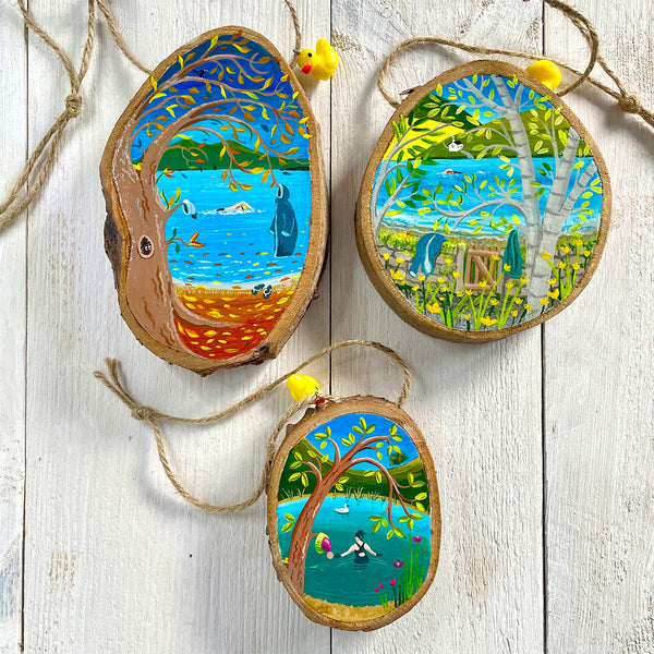 Set of three hand-painted log slice artworks featuring outdoor swimming scenes