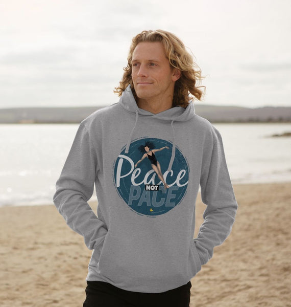 A swimmer stands by a quiet lake wearing a grey unisex organic-cotton hoodie with the “Peace Not Pace” wild-swimming design.