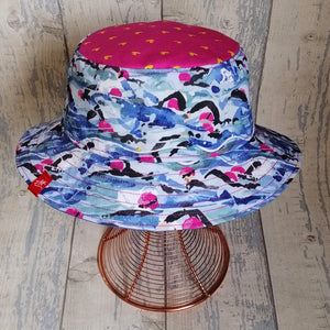 Reversible neon festival bucket hat with Andrea's iconic Mass Start swimmers design