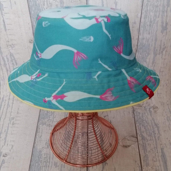 Reversible festival bucket hat. Blue and turquoise Swimming Mermaid design with yellow piping